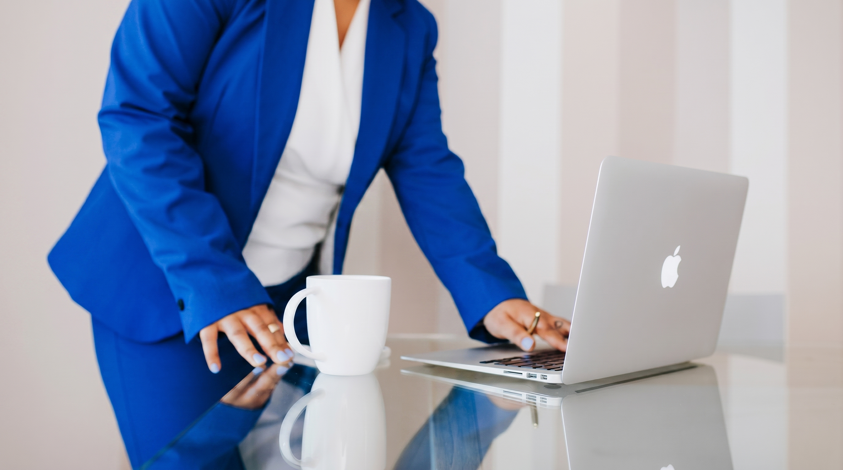A team member in a blue suit working on a laptop